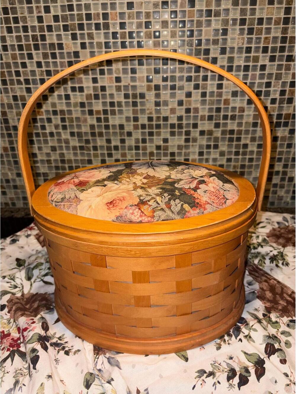 A vintage Longaberger tall round basket with padded floral lid.
